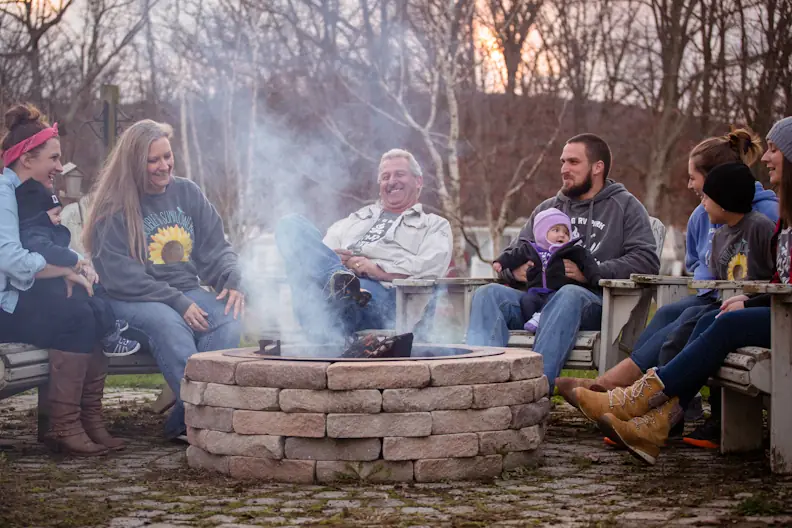 Campers gathered around a fire ring in the evening
