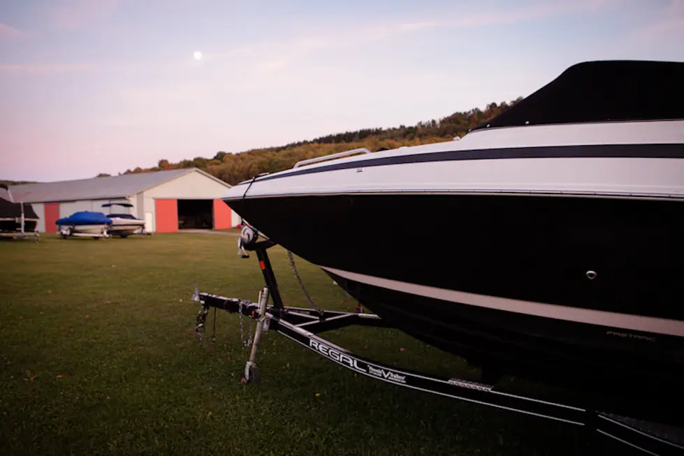 Red storage barn with a boat on its trailer in the evening